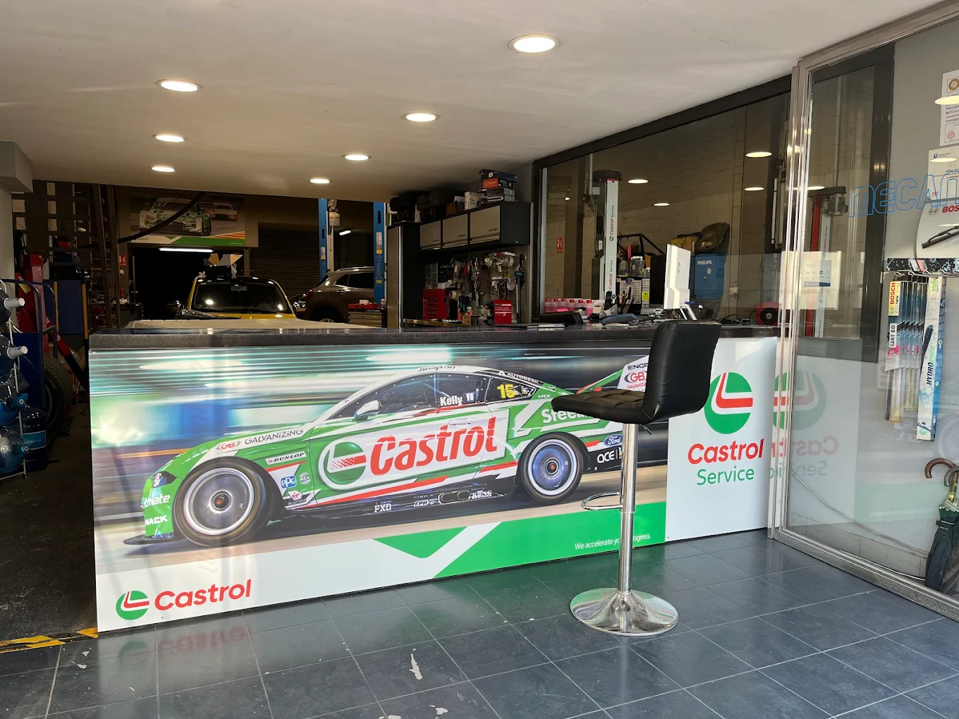 Interior del taller Mecánica Pérez con mural Castrol de competición